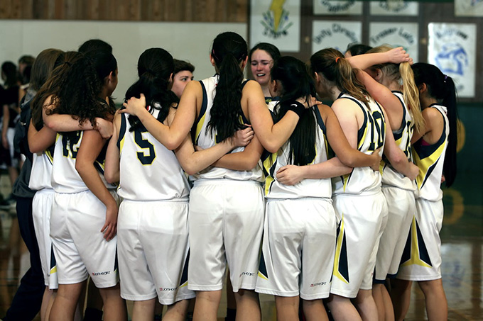 A girls basketball team in a huddle